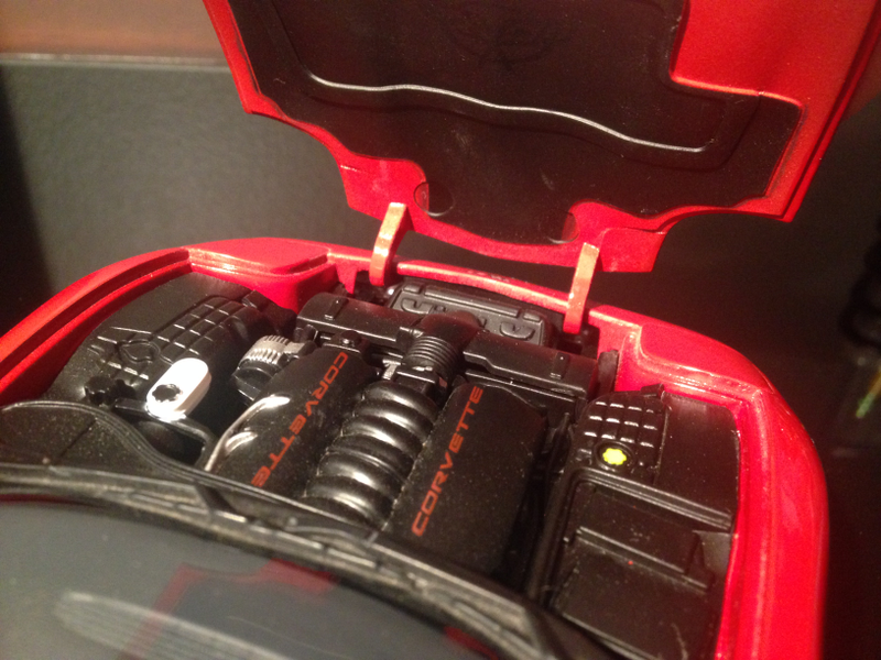 Engine bay has decent detail, with a few painted elements. Plastic graining is much more appropriate than the coarse textures found on the Bburago. Another nice touch is the painted underside of the hood, with logo.